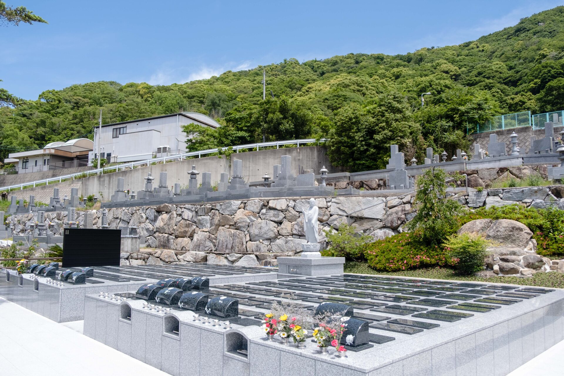 青空の下、山並みに抱かれた永代供養墓くおんの全景